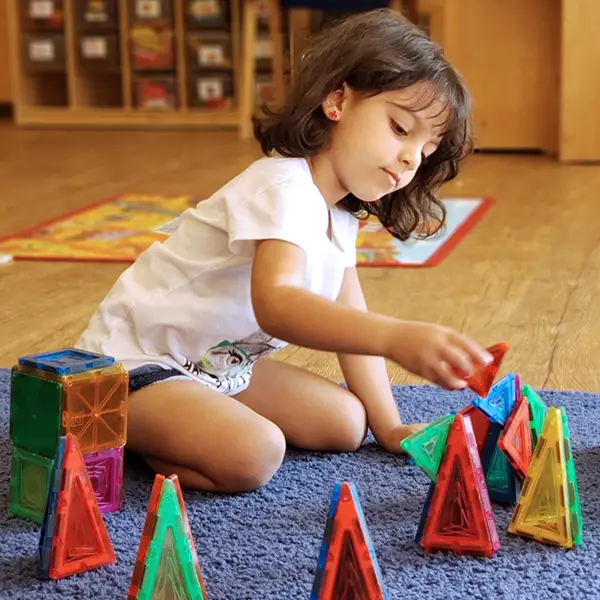Montessori girl learning with educational toys at The Merit School
