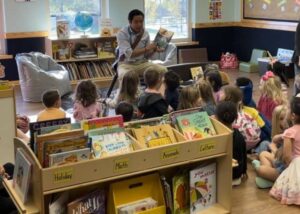 Merit School Learning Center at the Glen - teacher reading to children in facility library