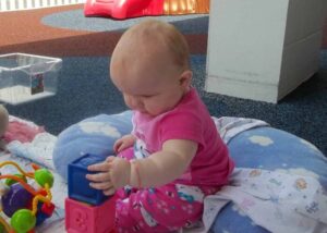 Merit School of Braemar infant playing with educational toys in Baby Steps room