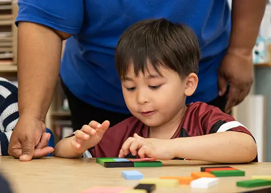Boy doing blocks geometry at Merit School at The Castle