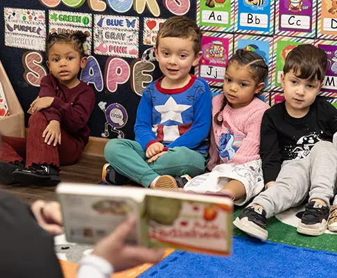 Teacher interacting with students in reading circle at The Merit School of Gunston