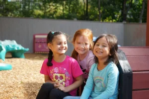 Three adorable girls on a playground train at The Merit School of Wellington